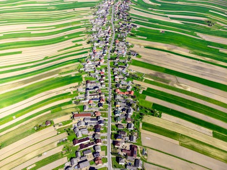 Stunning aerial view of a vibrant Polish village surrounded by lush fields in spring.
