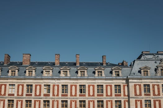 L'elegante facciata della Reggia di Versailles mette in mostra l'architettura classica francese sotto un limpido cielo azzurro.