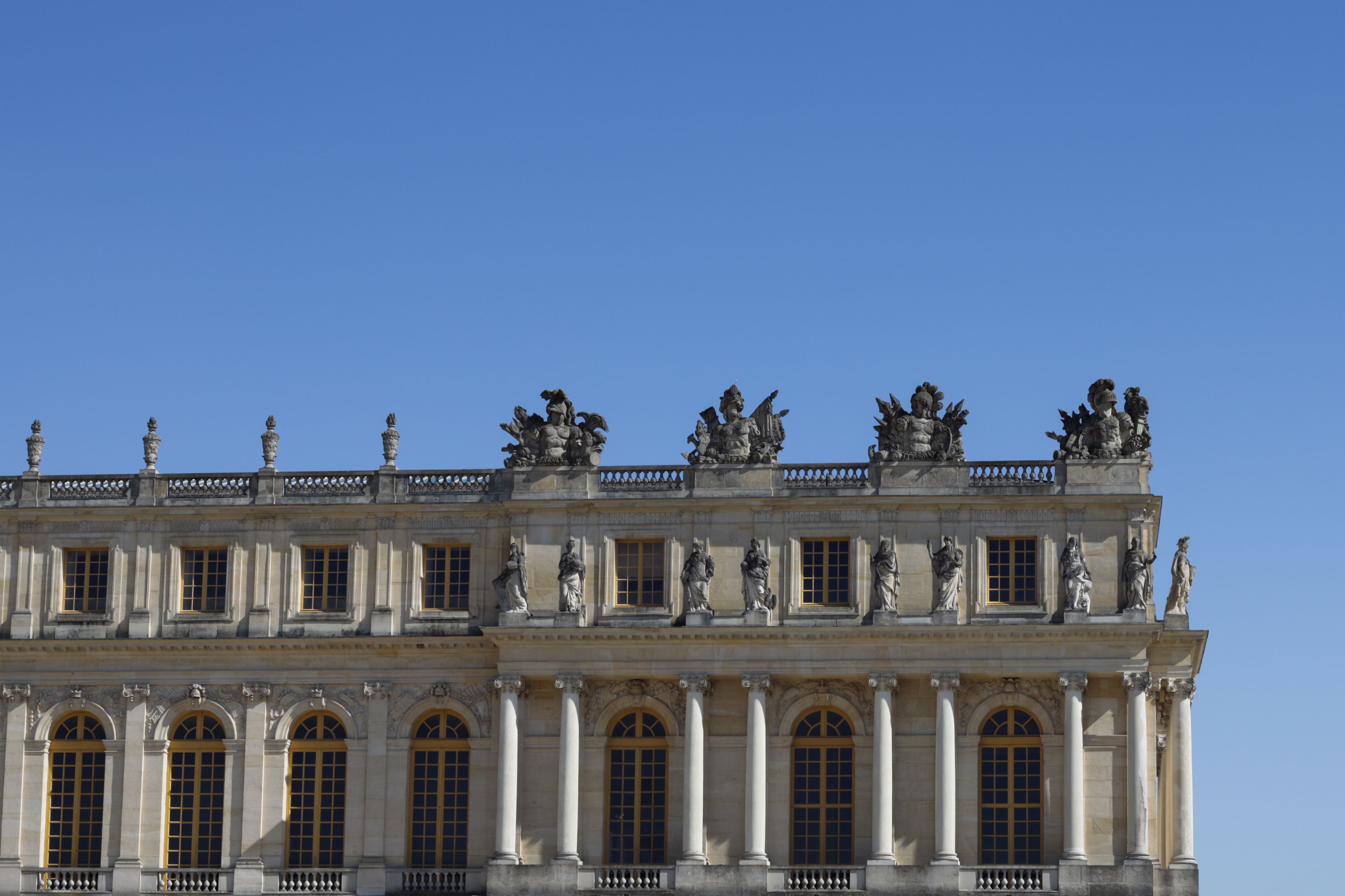 Elegant architecture of Versailles Palace under a clear blue sky in France.