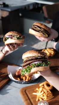 Enjoying hamburgers and fries outdoors with friends, capturing a perfect summer day.