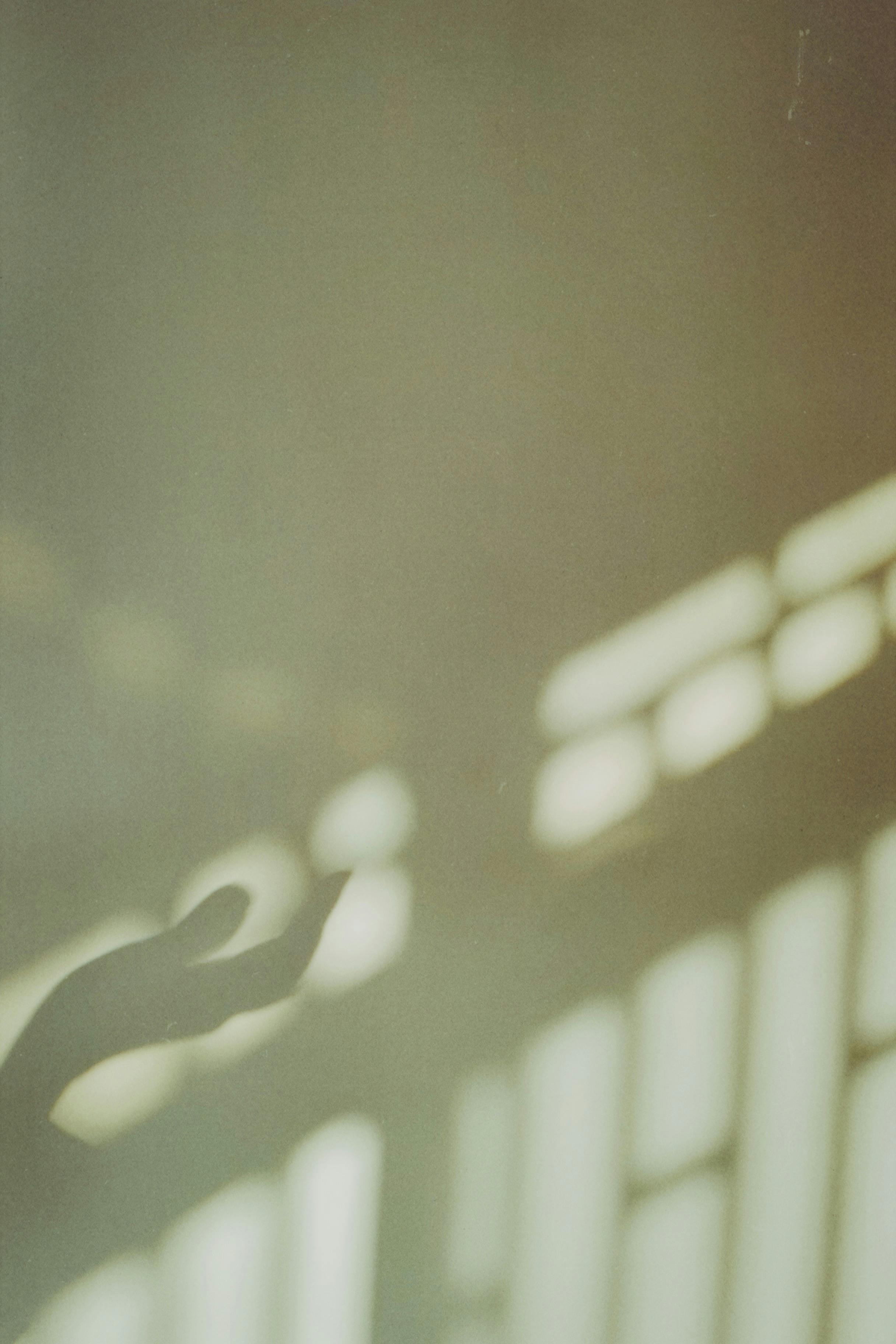 Kostenlos Abstraktes Bild, das den Schatten einer Hand auf einer sanft beleuchteten Wand zeigt und ein Gefühl des Geheimnisvollen hervorruft. Stock-Foto