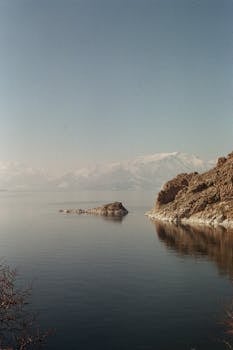 A tranquil view of Lake Van during winter with snow-covered mountains in Türkiye.