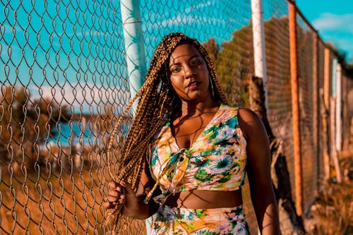 Photo Of Woman Standing Near Chain Link Fence