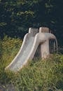 Abandoned Playground Slide in Overgrown Grass
