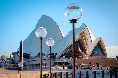 Free A striking daytime view of the Sydney Opera House with people enjoying a sunny day. Stock Photo