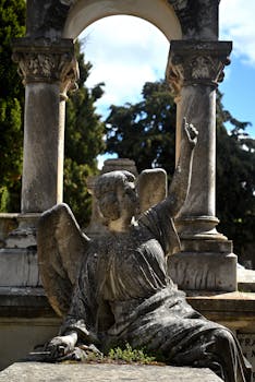 Sculptural angel beneath a stone arch in a cemetery in Soria, Spain.