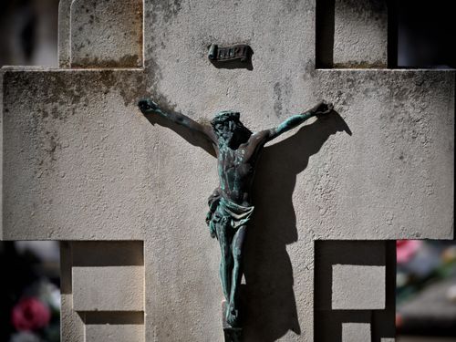 Free Close-up of a crucifix sculpture on a weathered stone cross in Soria cemetery. Stock Photo