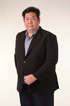 Formal portrait of a businessman in a suit against a neutral background, showcasing confidence and professionalism.