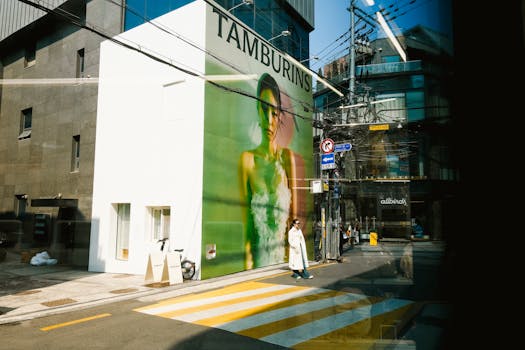 A city street with a large mural and pedestrian crossing on a sunny day.