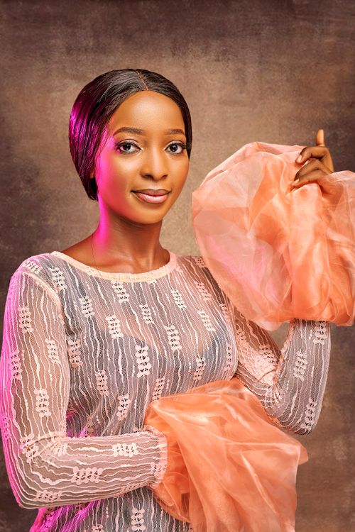 Free A stylish portrait capturing a woman in delicate lace with peach fabric. Stock Photo