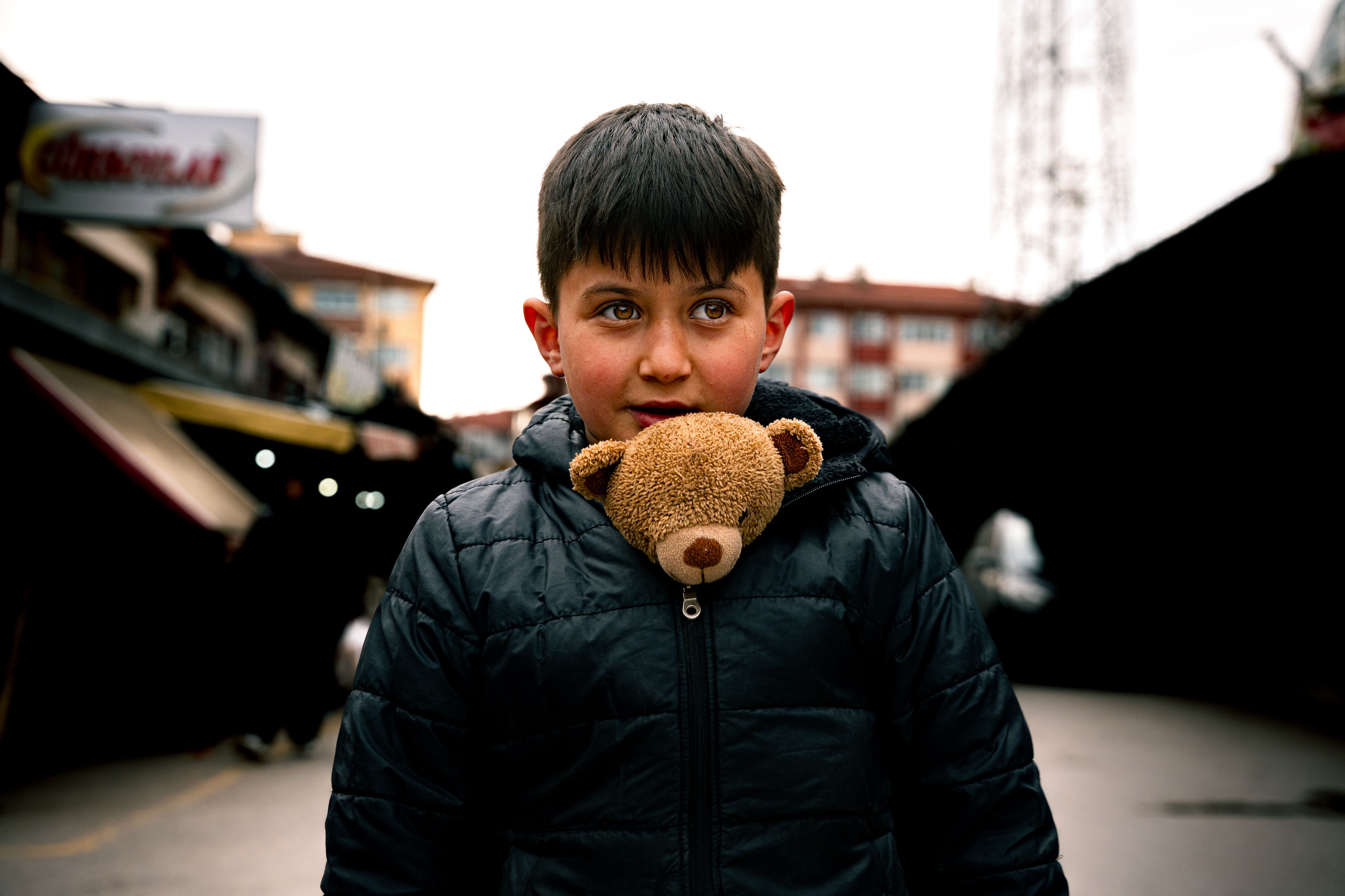 Young Boy with Teddy Bear in Urban Setting · Free Stock Photo