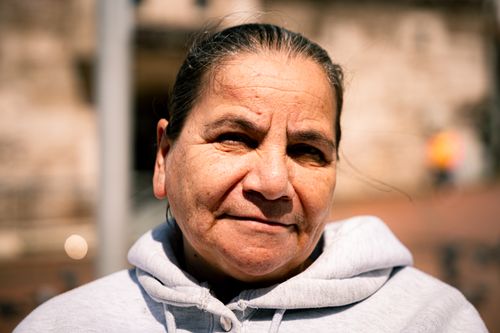 Free A candid close-up portrait of a mature woman wearing a hoodie, captured outdoors in natural light. Stock Photo