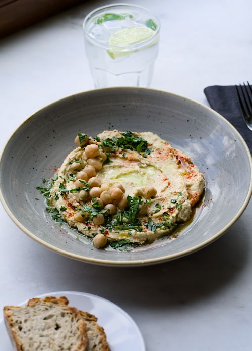 Free A close-up of hummus topped with chickpeas and herbs, perfect for a healthy snack. Stock Photo