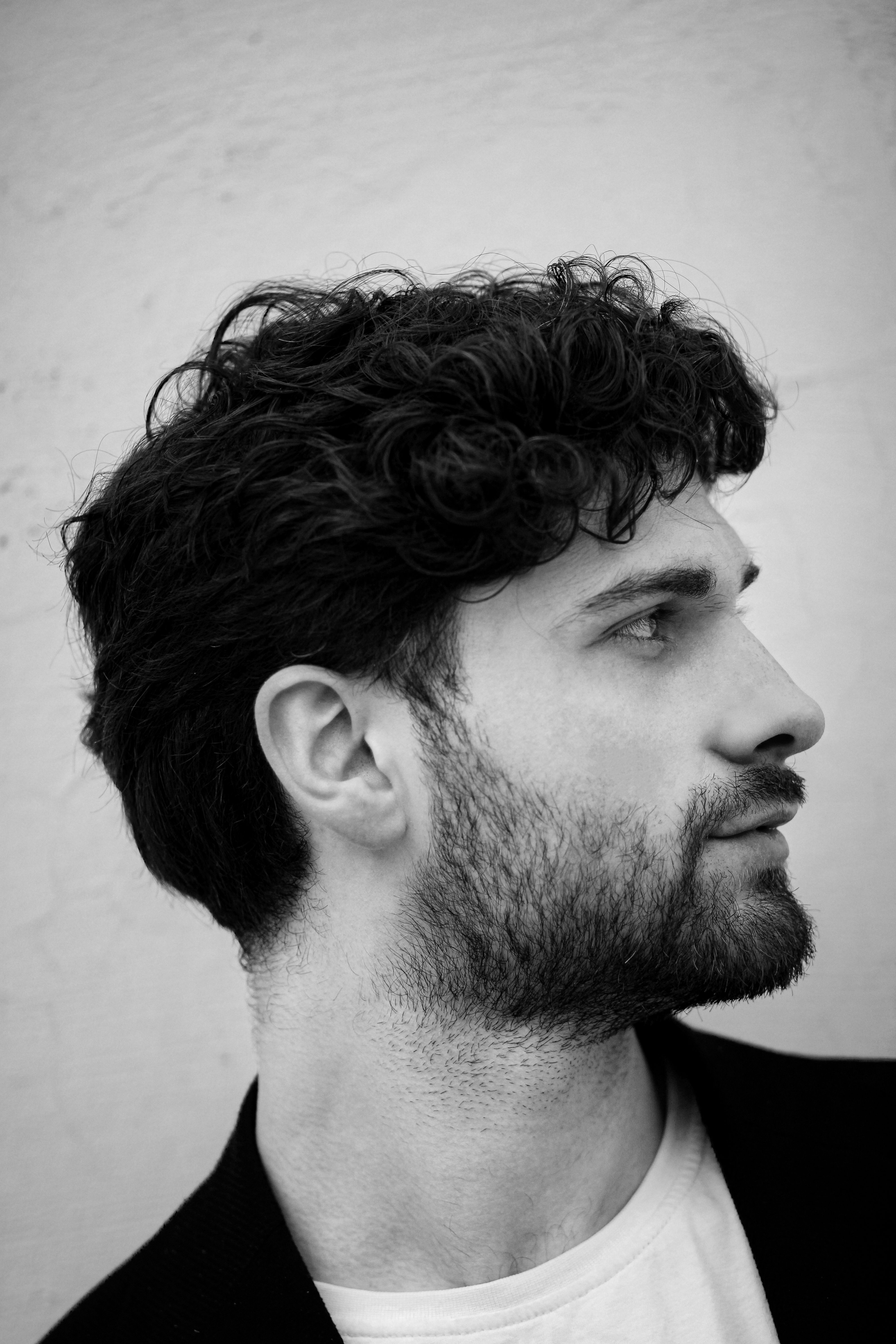 Black and White Portrait of a Man with Curls · Free Stock Photo