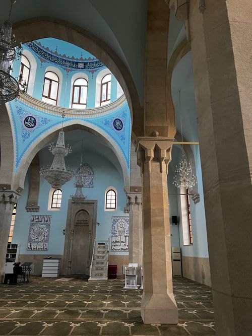 Free Interior view of a mosque showcasing intricate chandeliers and architectural beauty. Stock Photo