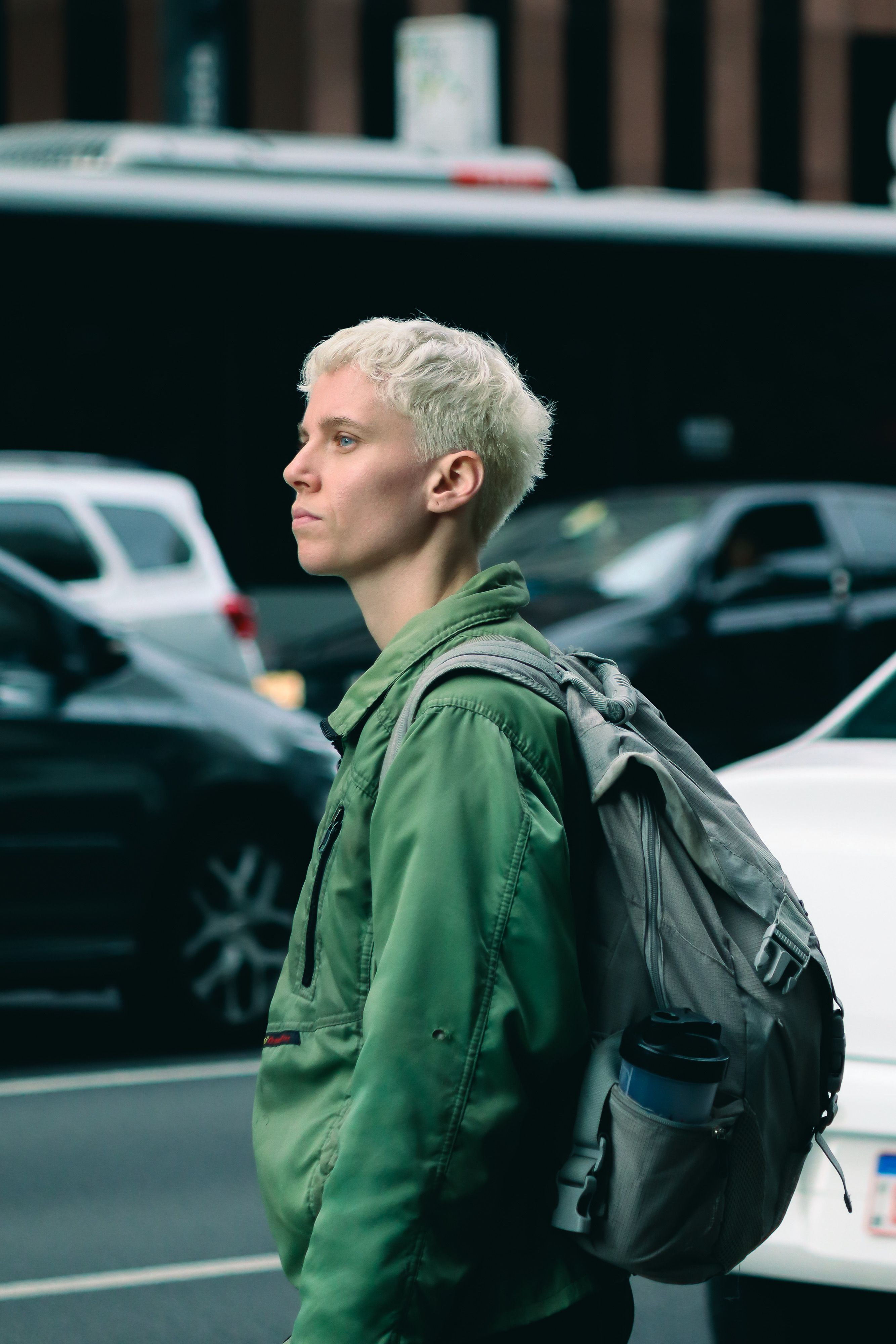 Candid street portrait of a person walking in urban São Paulo with traffic in the background.