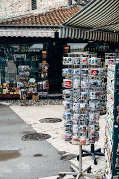 A street view of a souvenir shop in Sarajevo displaying mugs and magnets.