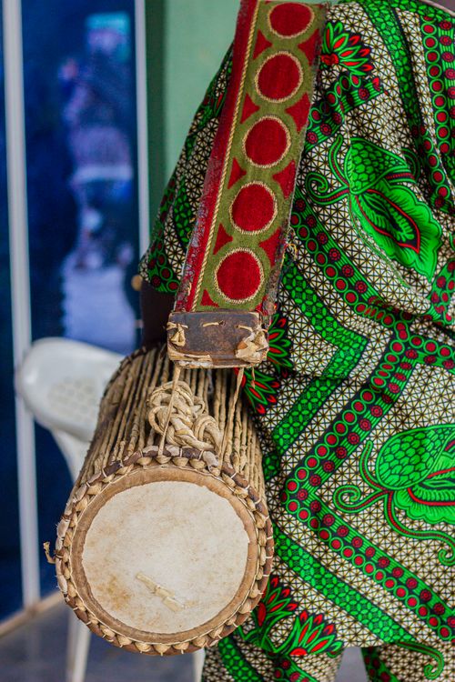 Free Vibrant African attire highlighting a Yoruba talking drummer with a unique traditional instrument. Stock Photo