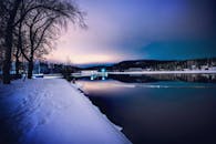 芬兰韦斯屈莱冬日傍晚宁静，湖面冰封，树木银装素裹