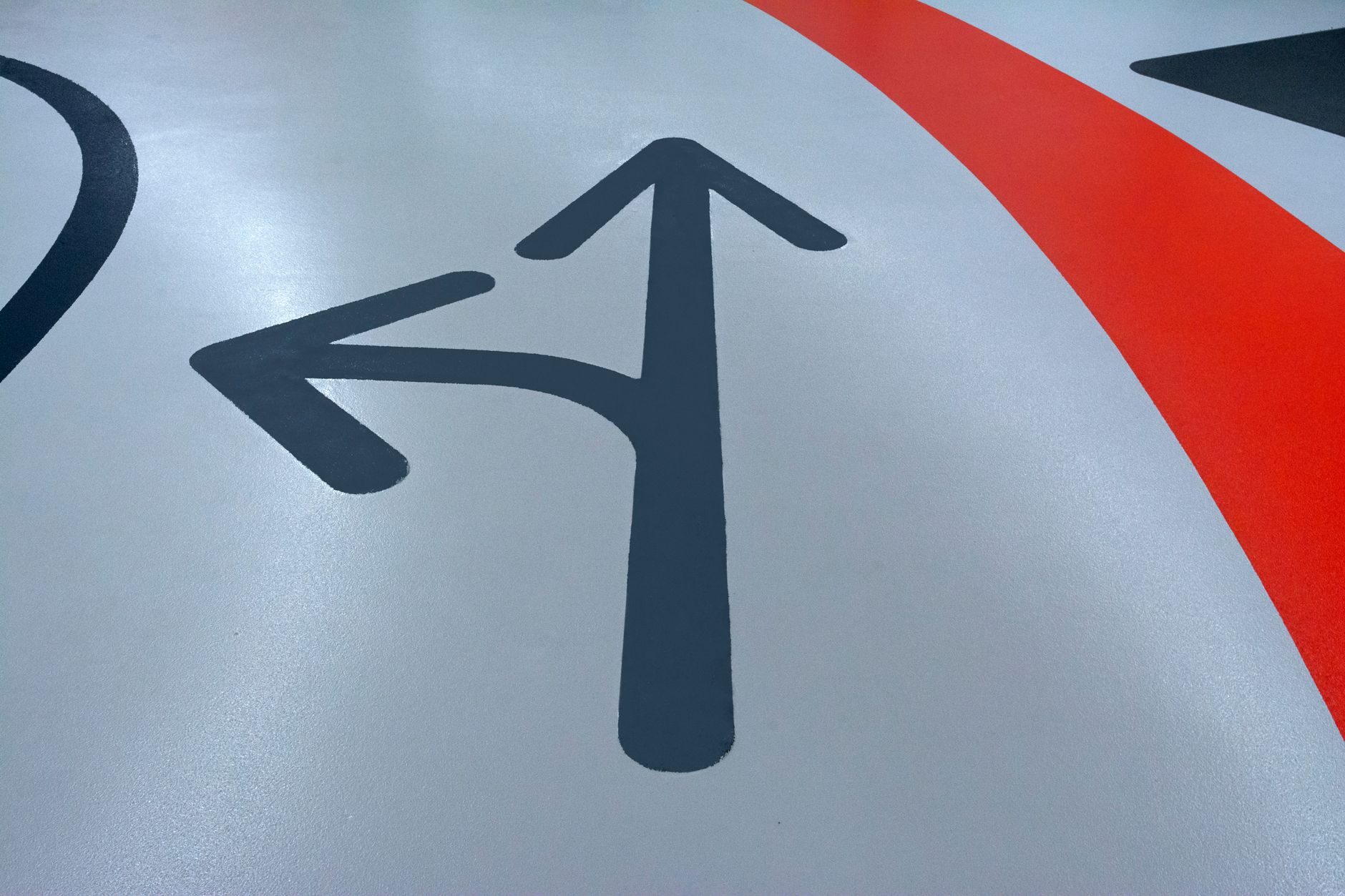 Close-up view of painted arrows on a parking garage floor indicating direction.