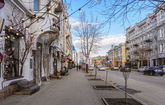 Charming city street scene with blooming flowers and classic architecture in early spring.