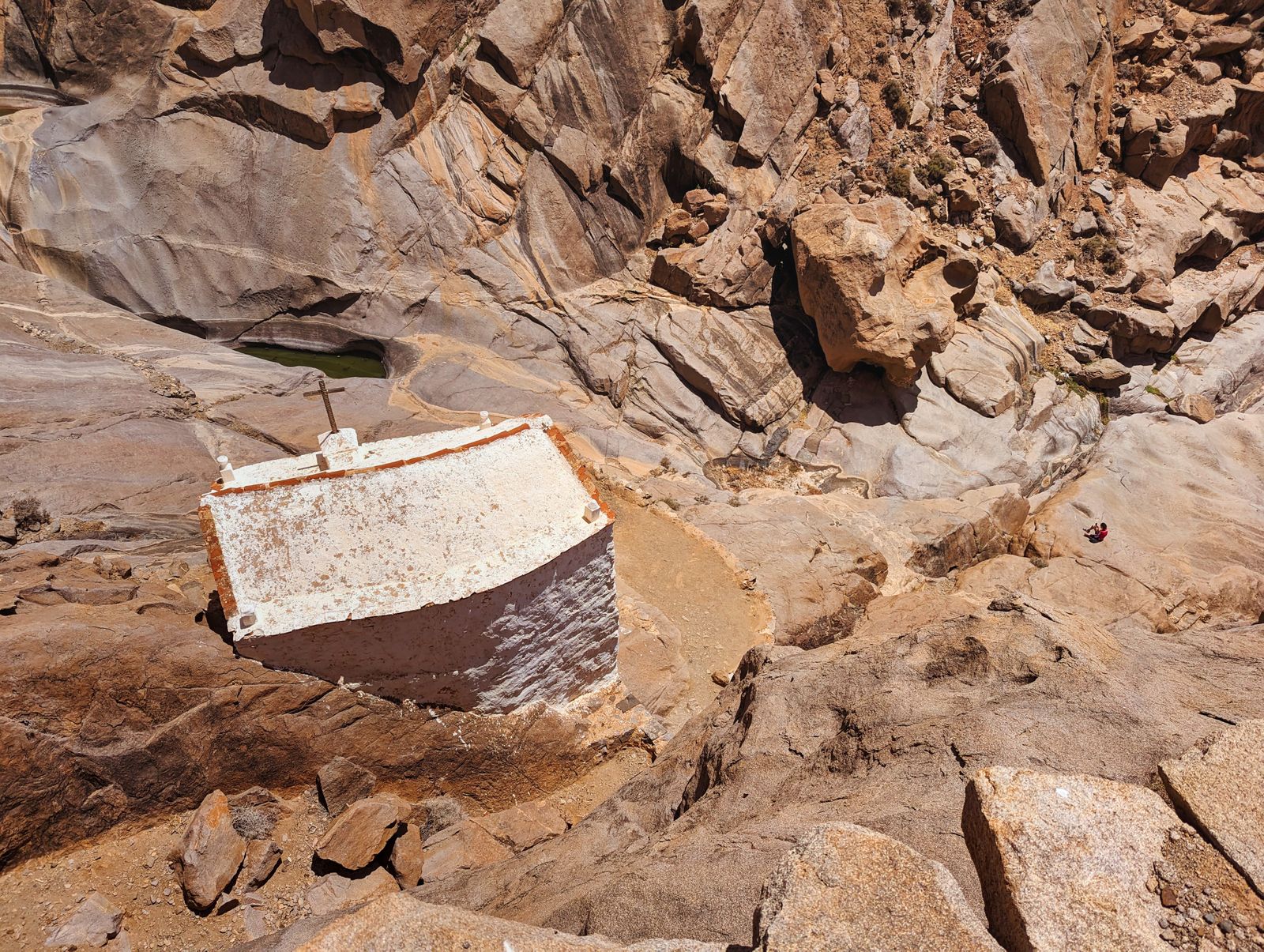 A solitary chapel nestled within the rugged, arid landscape of Fuerteventura's rocky hillsides