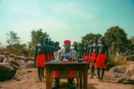 Vibrant outdoor group portrait with men in red shorts and glasses, creating a striking composition.