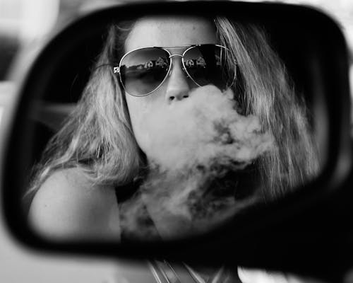 Reflection of Woman Releasing Smoke from Mouth 
