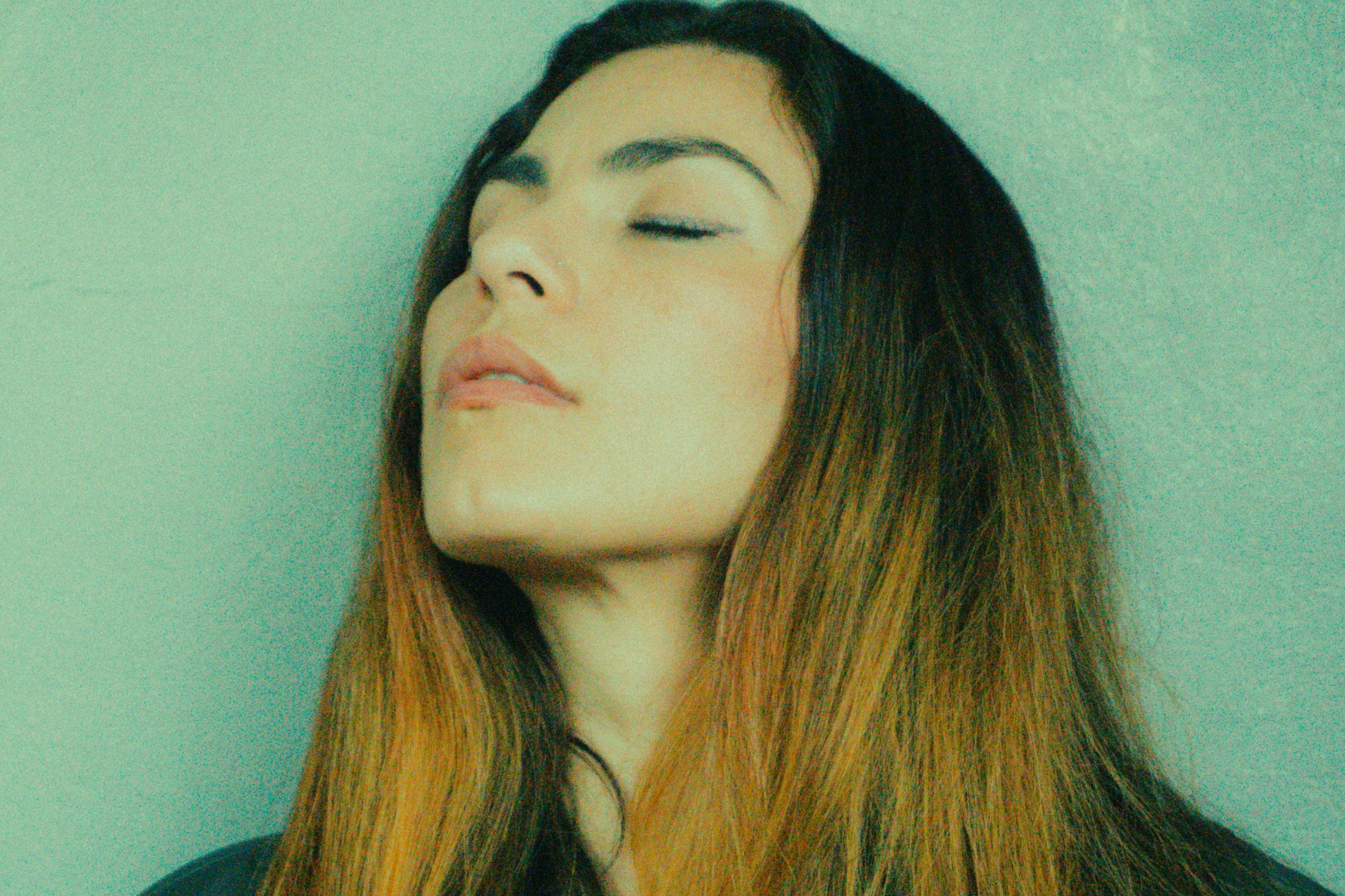 資訊焦慮怎麼辦?數位時代過載的實用應對策略 Portrait of a woman with long hair and closed eyes conveying tranquility and introspection.
