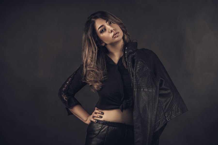 Model in black leather posing in a dark studio &mdash; photo by Farzad Sedaghat on Pexels