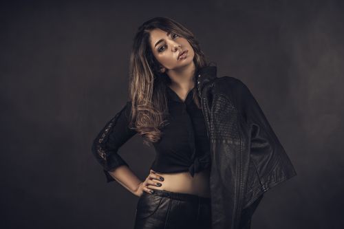 Free Stylish woman in black leather posing confidently in studio setting. Stock Photo