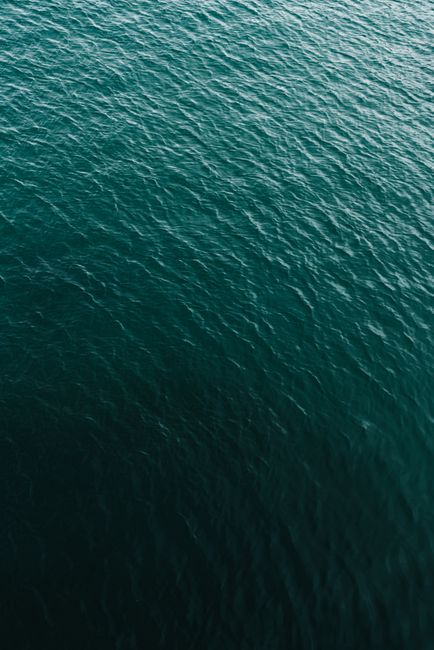Captivating aerial view of deep green ocean waves and ripples with a serene atmosphere.