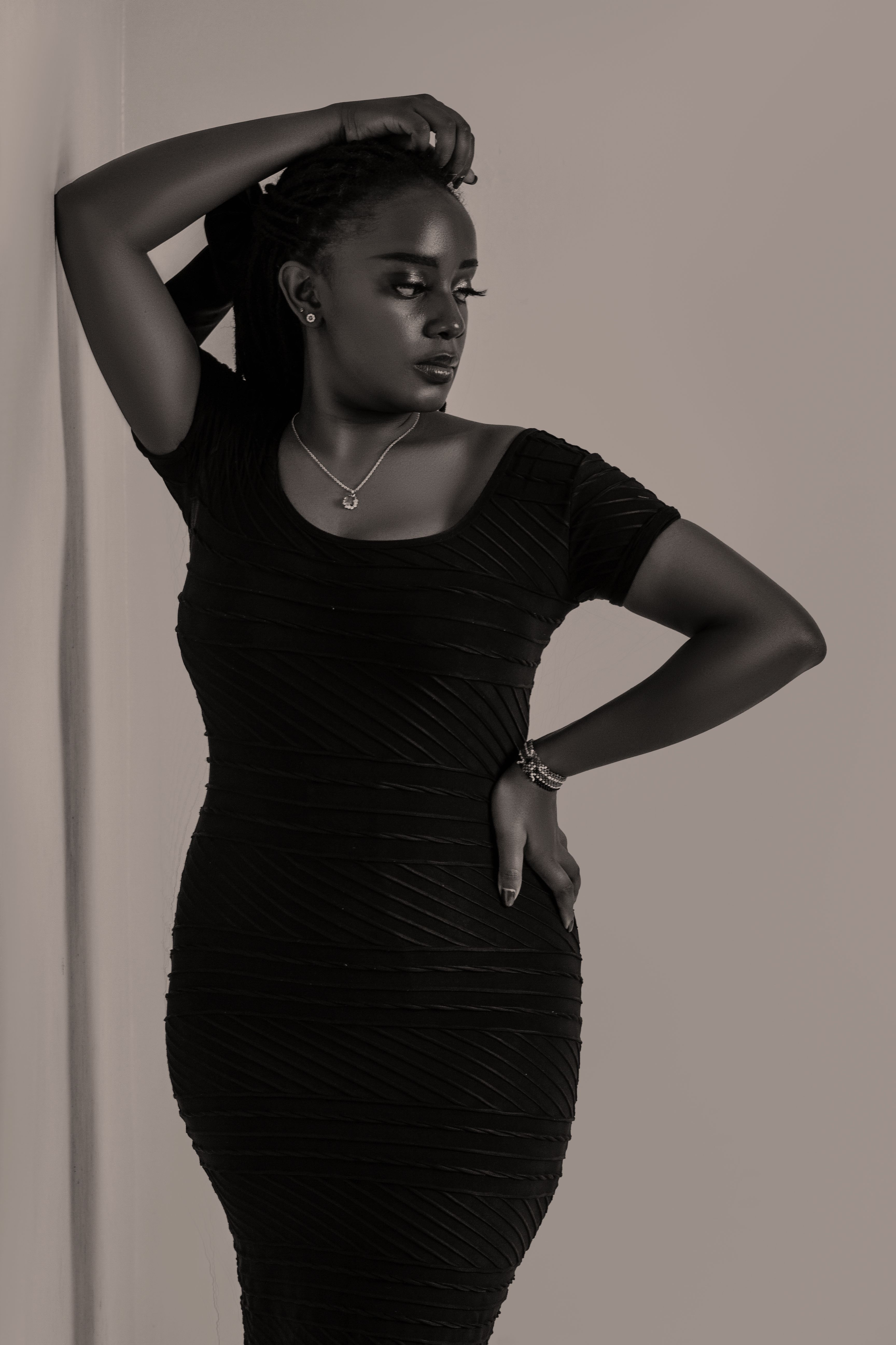Stylish black and white portrait of a woman in an elegant black dress, showcasing timeless fashion and elegance.