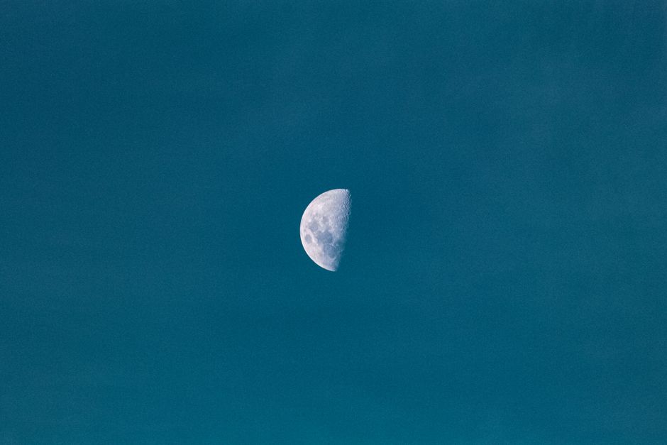 Captivating crescent moon against a vast deep blue sky, showcasing celestial beauty.