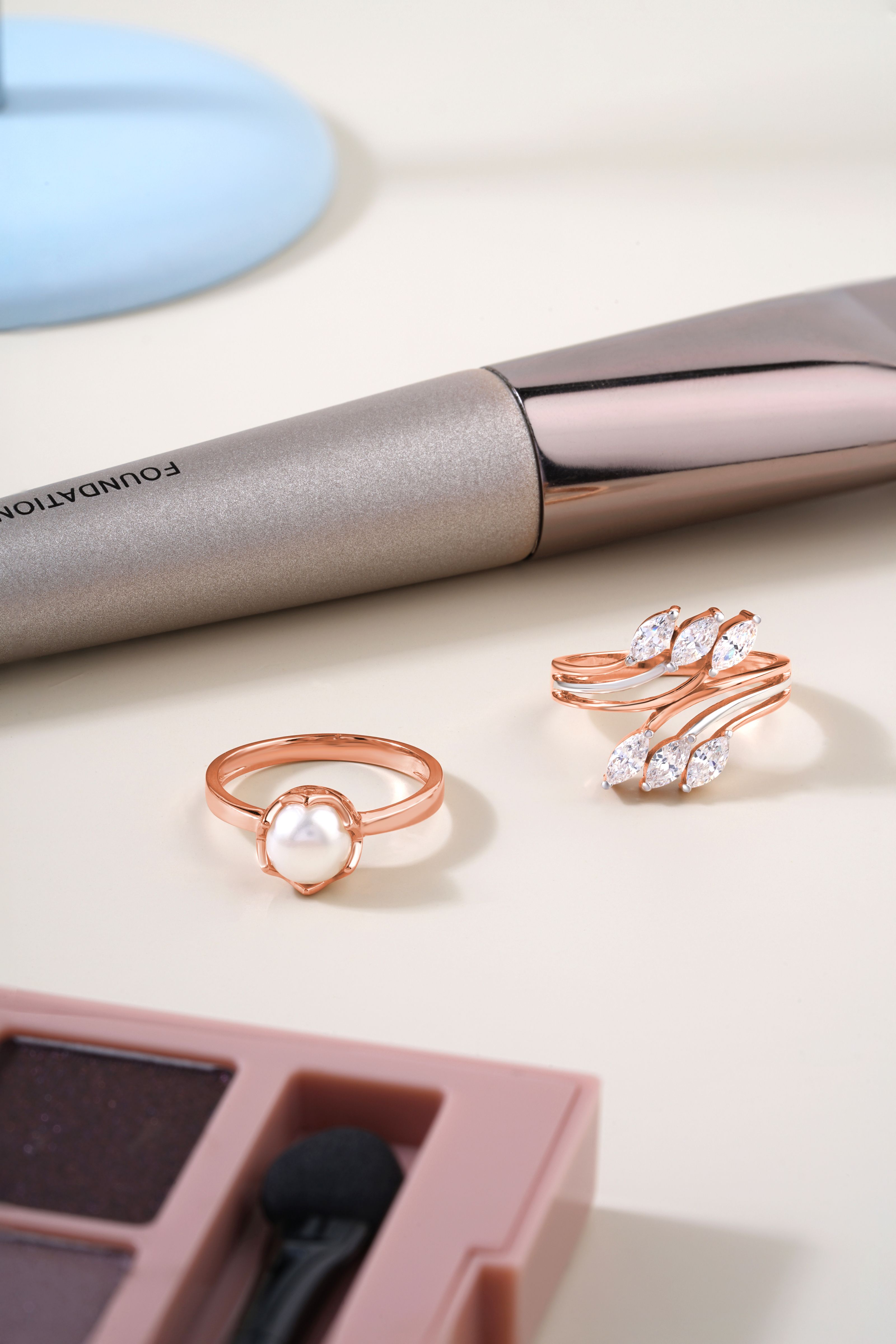 Uma exibição chique de anéis de pérolas e diamantes com acessórios de maquiagem.