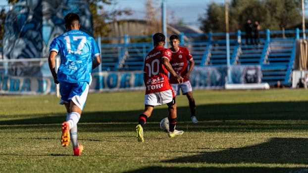 Soccer players competing during a thrilling outdoor match on a sunny day.