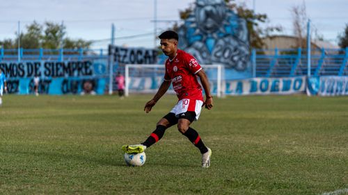 Free A soccer player in red jersey dribbles during a match on a sunny day. Stock Photo