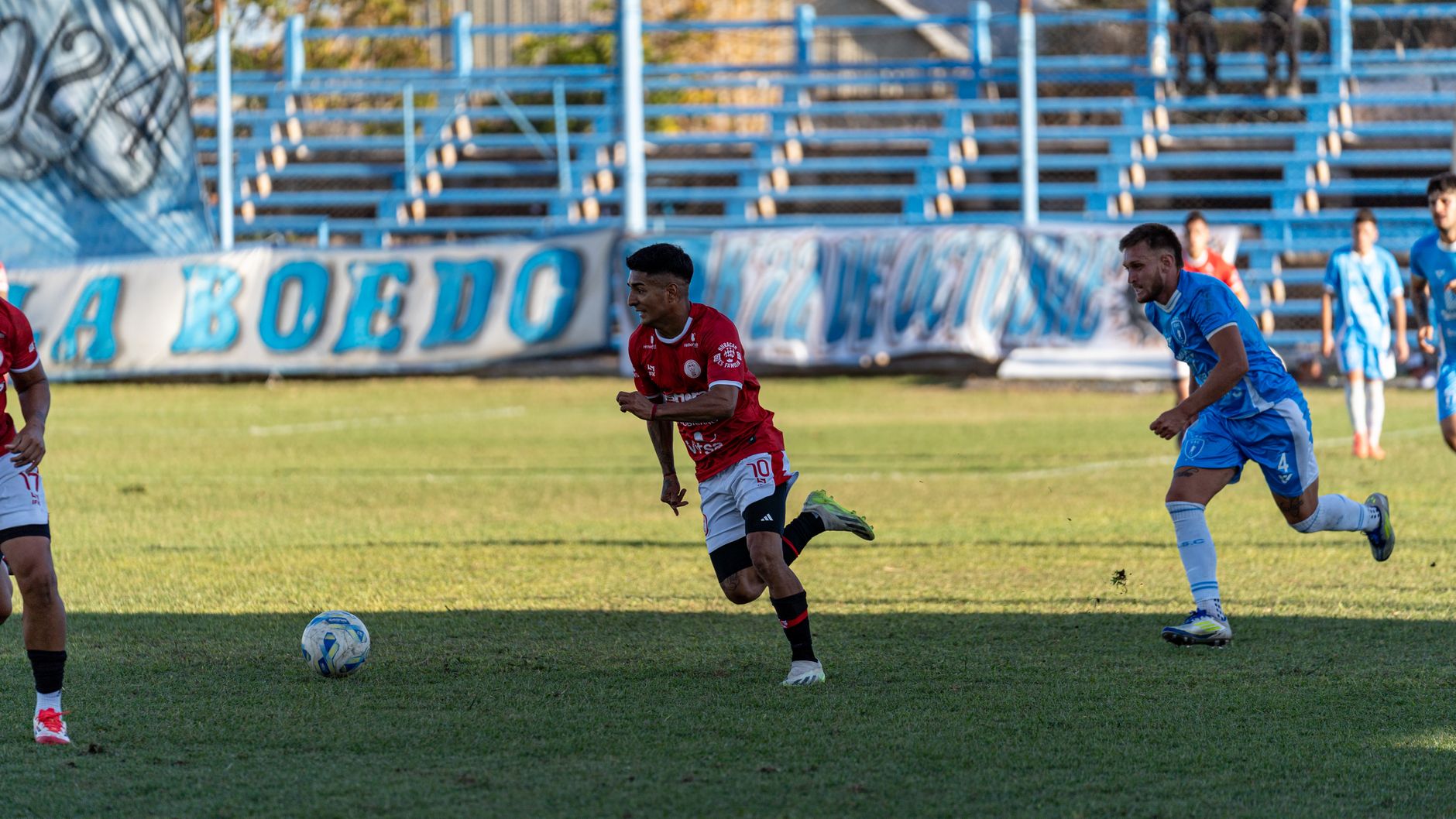 Players compete in an exciting soccer match on a sunny day.