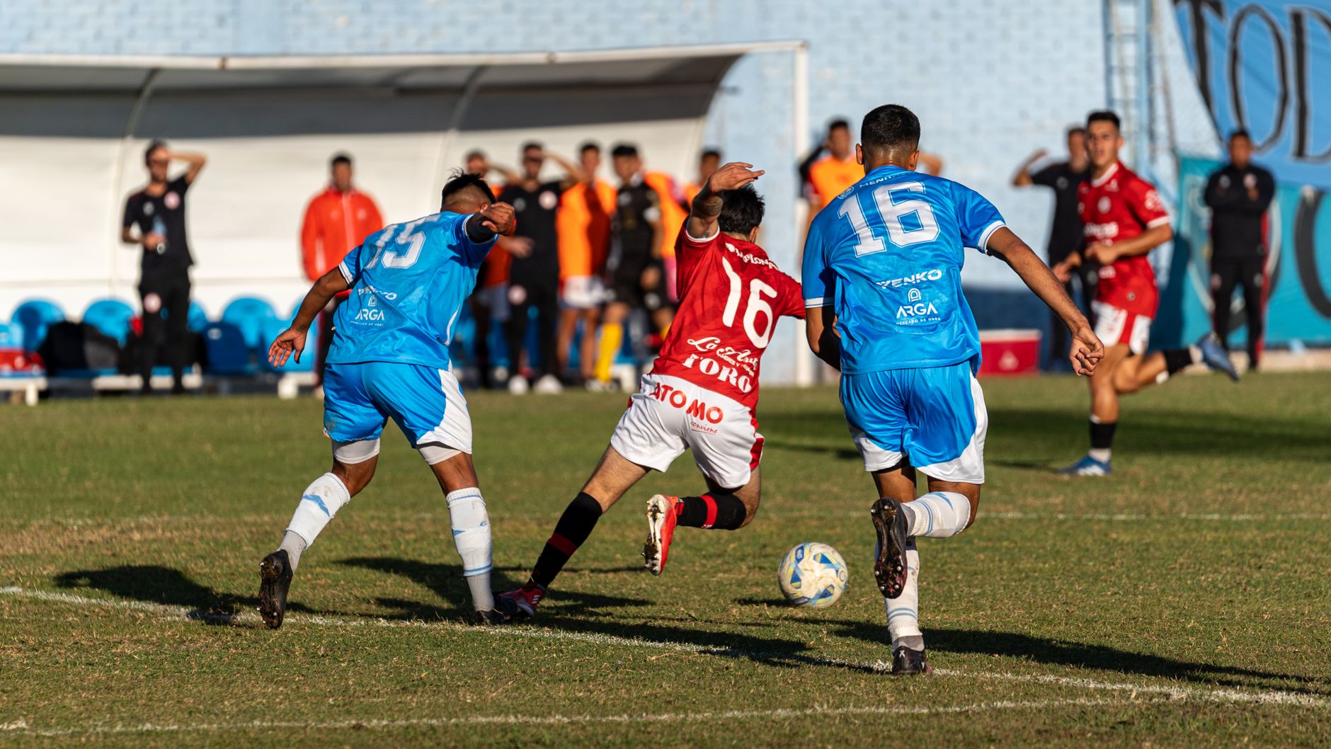 Action-packed soccer match with players competing for the ball on a sunny day.