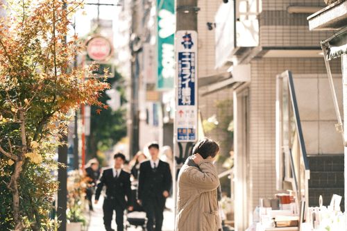 Free Bustling street in Japan featuring people, autumn leaves, and signage. Stock Photo