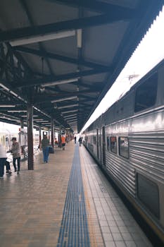 People boarding a train at a covered platform in an Australian railway station.