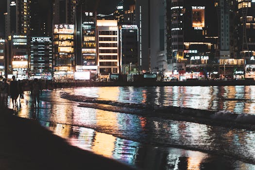 Captivating city lights reflecting on the water at Gwangan Beach in Busan, South Korea at night.