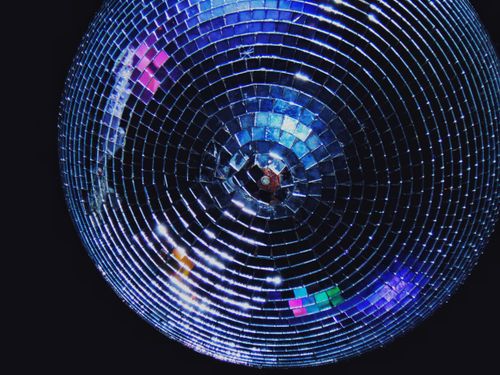 Free Close-up of a sparkling disco ball reflecting colorful lights in the dark, capturing a party atmosphere. Stock Photo