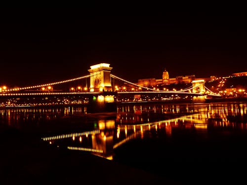 Illuminated Bridge over River at Night