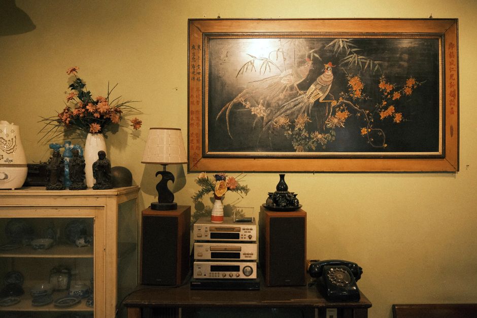 Skandynawski salon z zestawem stereo, panelami na ścianie i grubym dywanem w odcieniach szarości