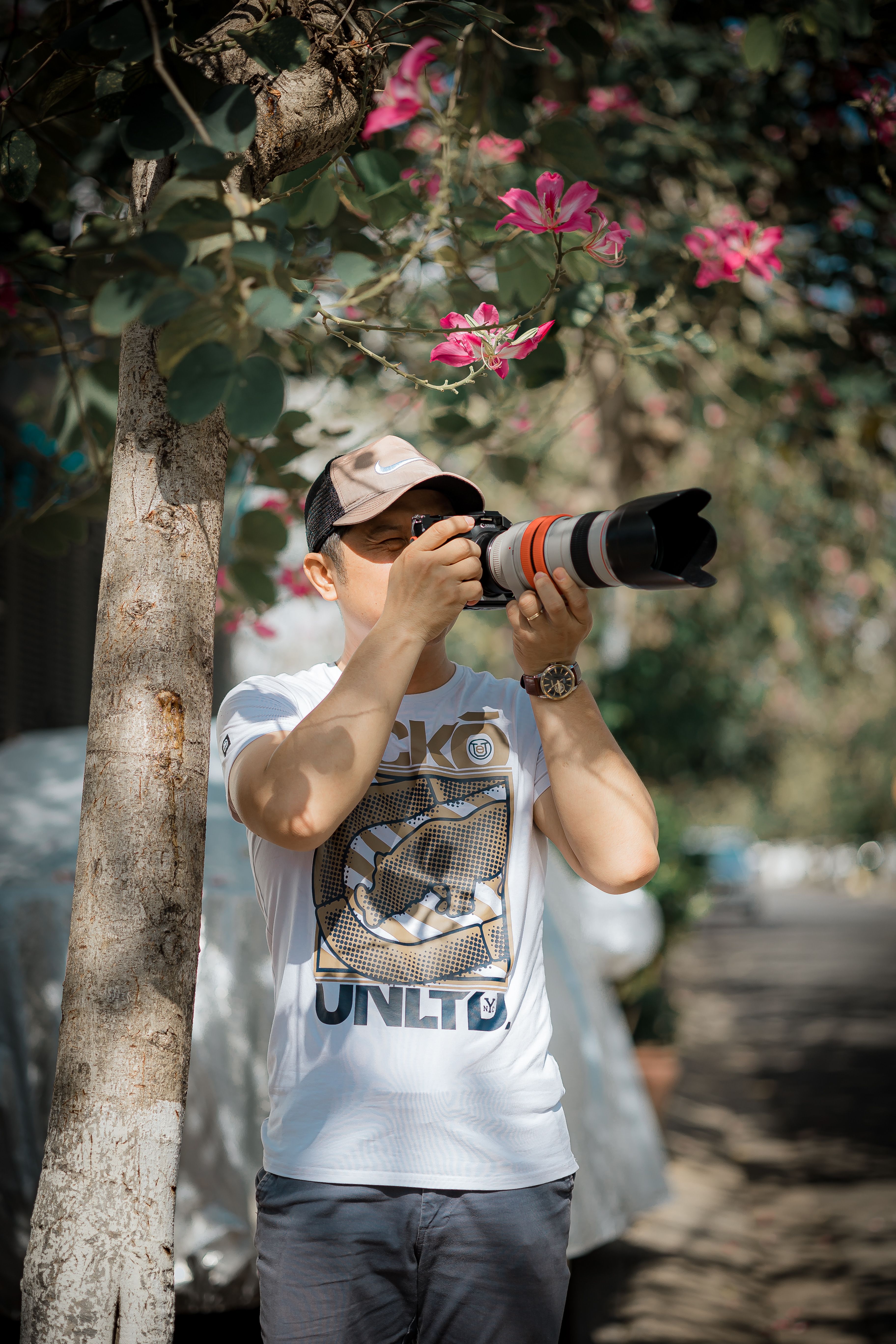 Male photographer uses a telephoto lens to capture nature outdoors.