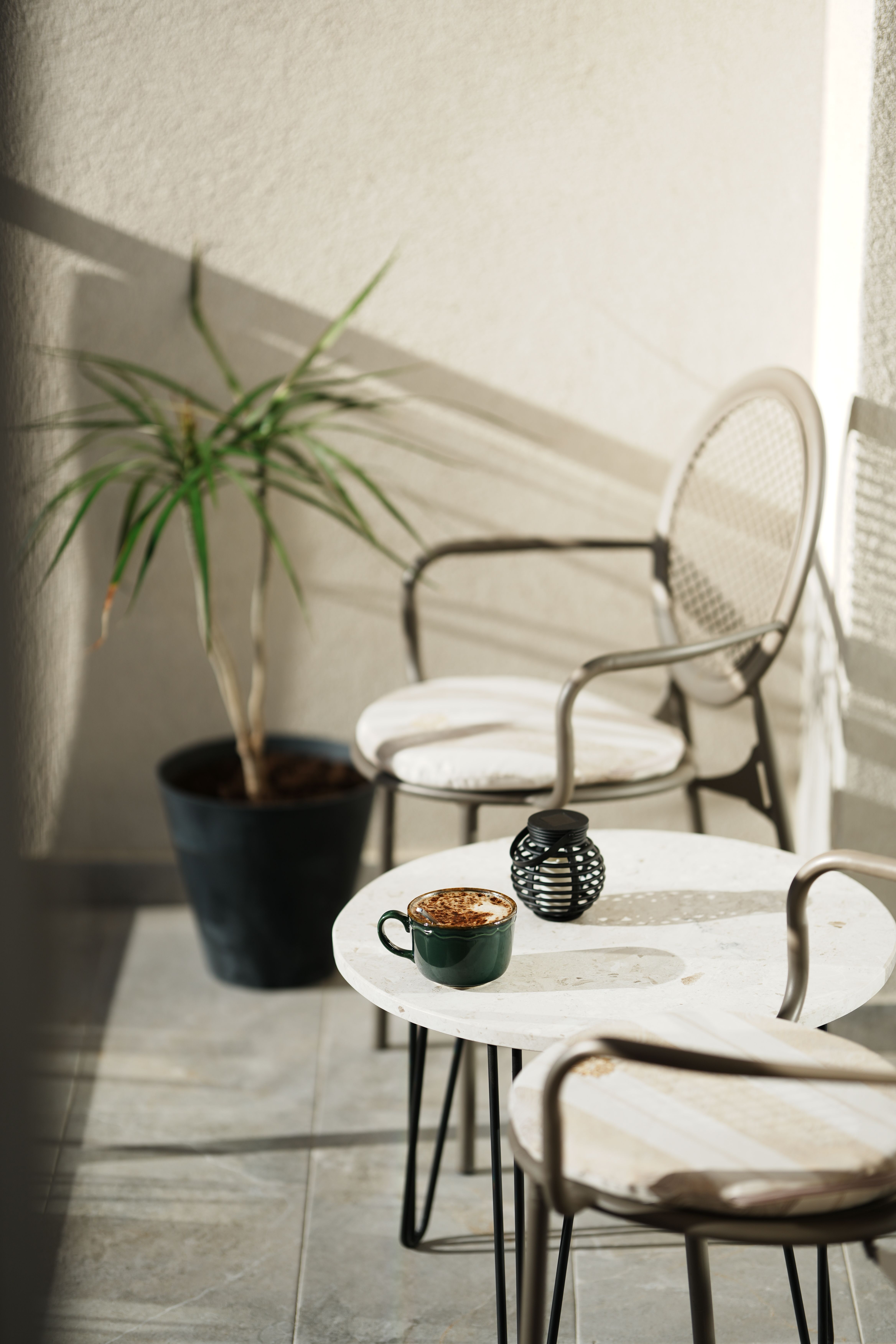 Minimalist small apartment balcony decor in white and neutral tones with coffee