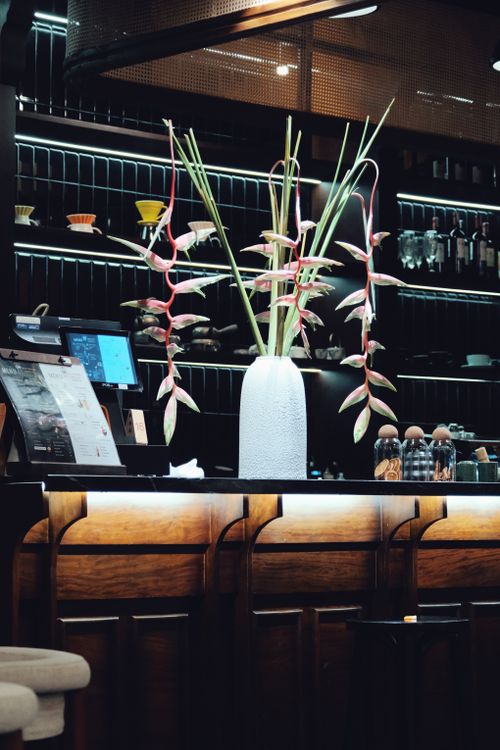 Free Chic bar interior featuring elegant arrangements of Heliconia flowers on a counter. Stock Photo