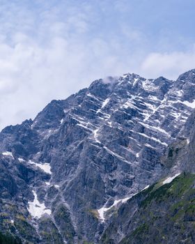 Majestic snow-dusted mountain peaks with a dramatic rocky terrain and partly cloudy sky. 31608768