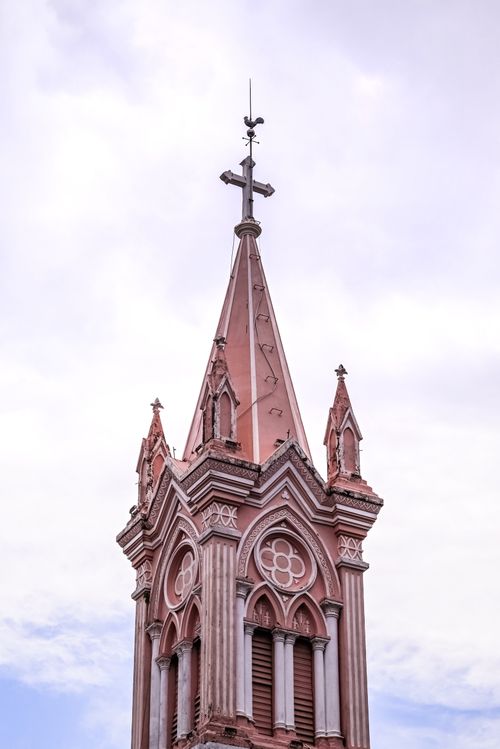 Free Elevated view of a Gothic church steeple adorned with ornate details beneath a clear sky. Stock Photo